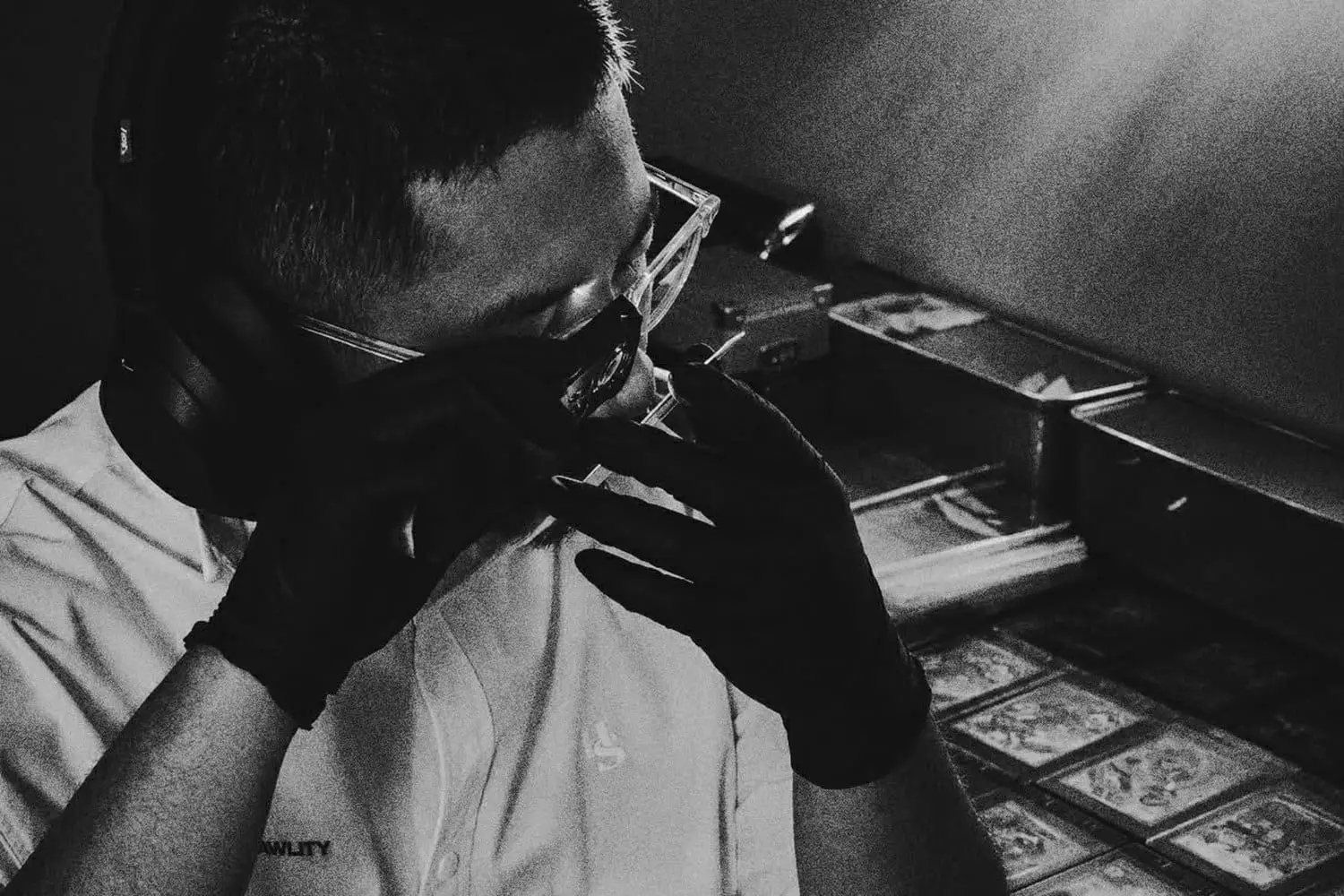 RAWLITY grader inspecting a card under a loupe
