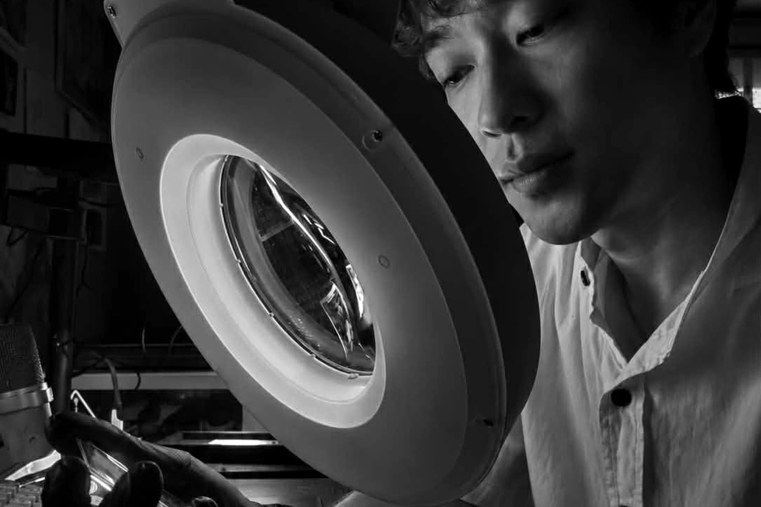 A RAWLITY grader examining a card under a magnifier lamp